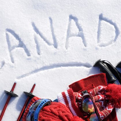 The word Canada written in snow with ski poles, goggles and hats (picture taken in fresh snow with directional winter sun).